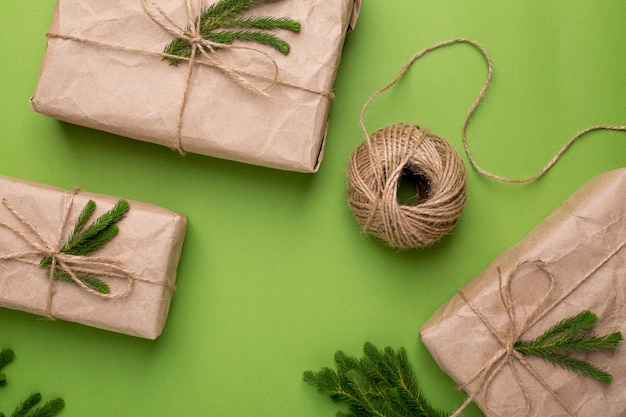 Foto regalos ecológicos con plantas verdes en papel artesanal sobre una superficie verde