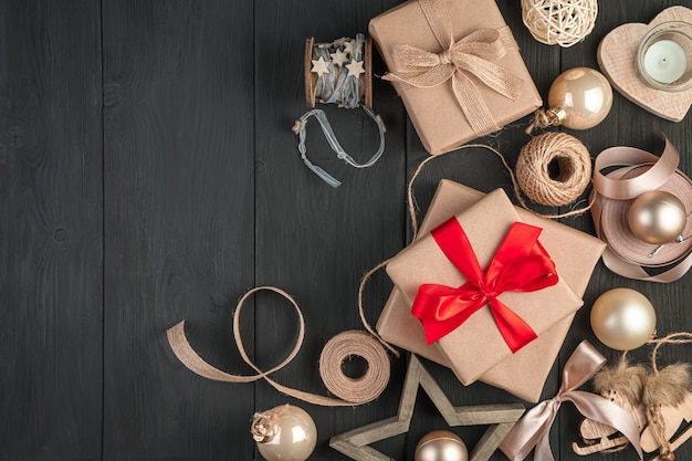 Regalos empaquetados con cintas rojas y beiges sobre fondo negro. Feliz navidad y próspero año nuevo.