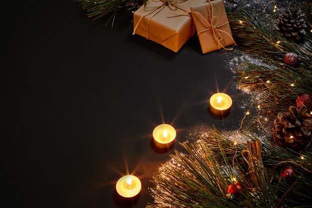 Regalos de Navidad, árbol de Navidad, velas, decoración de colores, estrellas, bolas sobre fondo negro. Vista superior. Copie el espacio. Naturaleza muerta, plano, nuevo, año