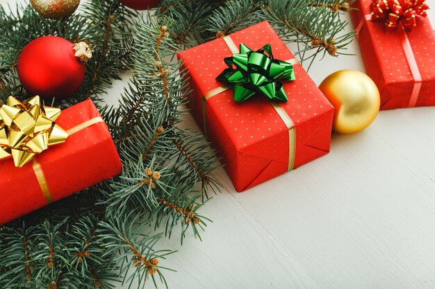 Regalos de Navidad Cajas de regalos de Navidad en ramas de abeto, bolas sobre fondo blanco. Espacio de copia de año nuevo