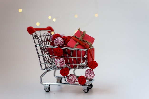 Regalos de Navidad en un carrito de supermercado en blanco