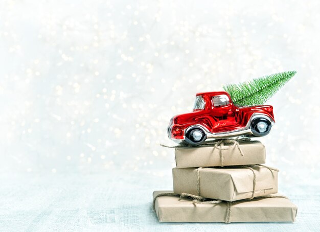 Regalos de Navidad y coche de juguete rojo. Decoración de vacaciones de invierno