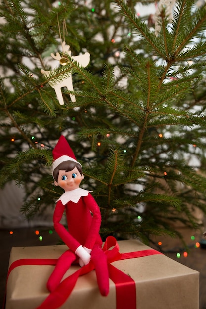 Regalos de Navidad envueltos en papel artesanal y bonito juguete elfo cerca del árbol de Navidad