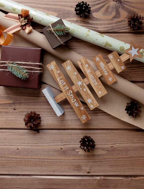 Regalos de Navidad envueltos en papel artesanal sobre mesa de madera. Proceso de envolver regalos.