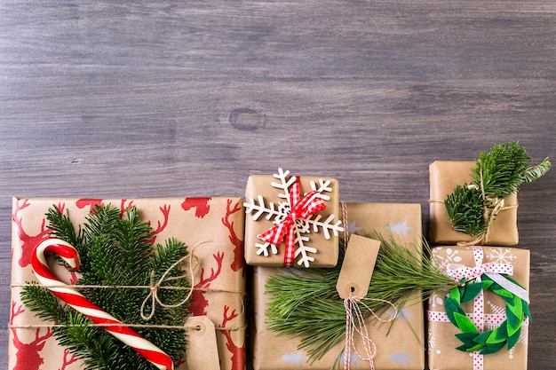 Regalos de Navidad envueltos en papel marrón con cintas rojas.