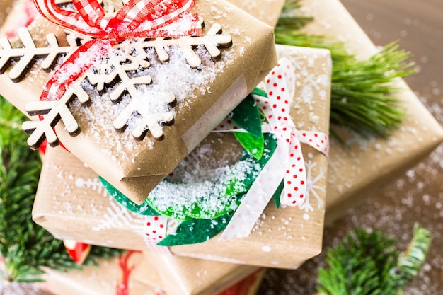 Regalos de Navidad envueltos en papel marrón con cintas rojas.