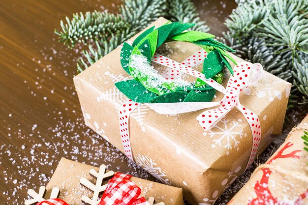 Regalos de Navidad envueltos en papel marrón con cintas rojas.