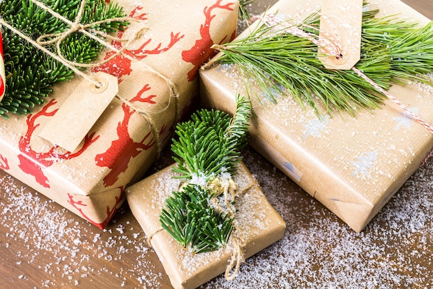 Regalos de Navidad envueltos en papel marrón con cintas rojas.