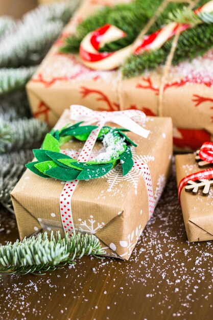 Regalos de Navidad envueltos en papel marrón con cintas rojas.