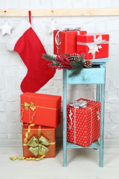 Regalos de Navidad en la estantería azul sobre fondo de pared de ladrillo