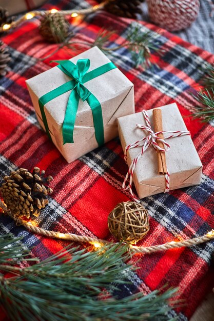 Regalos de Navidad con guirnaldas de piñas y ramas de abeto, un bello bodegón