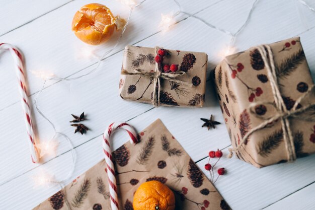 Regalos de Navidad, piruleta, mandarina sobre fondo blanco de madera. Foto de alta calidad