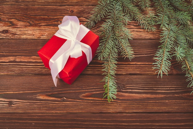 Regalos de Navidad y ramas de pino en mesa de madera, vista superior