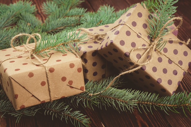 Regalos de Navidad y ramas de pino en mesa de madera, vista superior