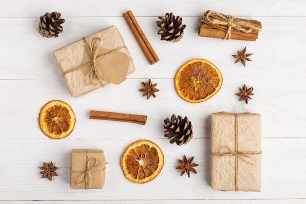 Regalos de papel kraft y especias en una mesa blanca