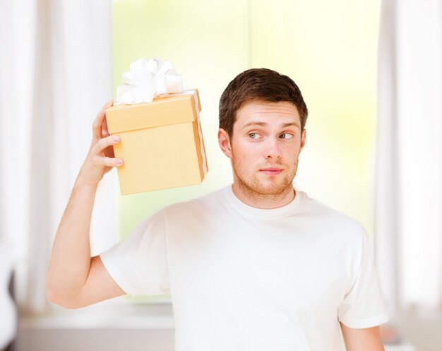 regalos, regalos y celebración - hombre de camiseta blanca con caja de regalo