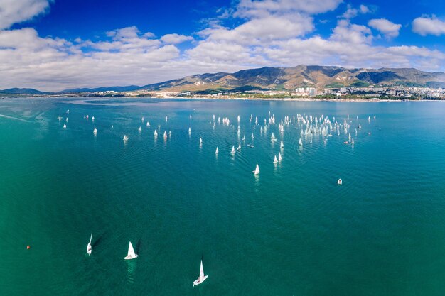 Regata de vela na baía de Gelendzhik Numerosas velas brancas nas águas esmeraldas do Mar Negro