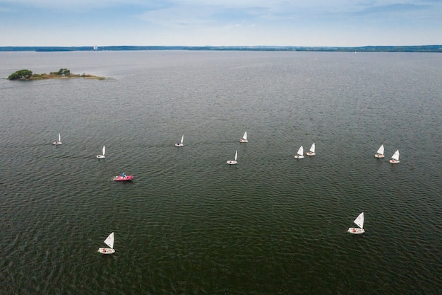 Regata de vela no mar. muitas velas brancas flutuam na água