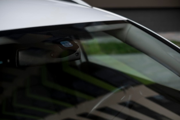 Regen- und Scheinwerfersensoren an der Windschutzscheibe eines Autos.