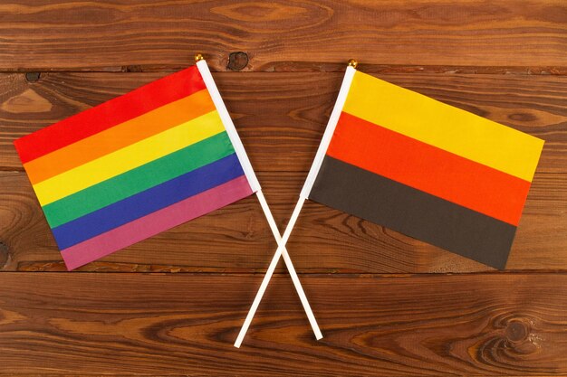 Regenbogen-LGBT-Flagge und Flagge Deutschlands auf braunen Holzplatten Hintergrund LGBT Pride-Monat LGBTQ LGBT