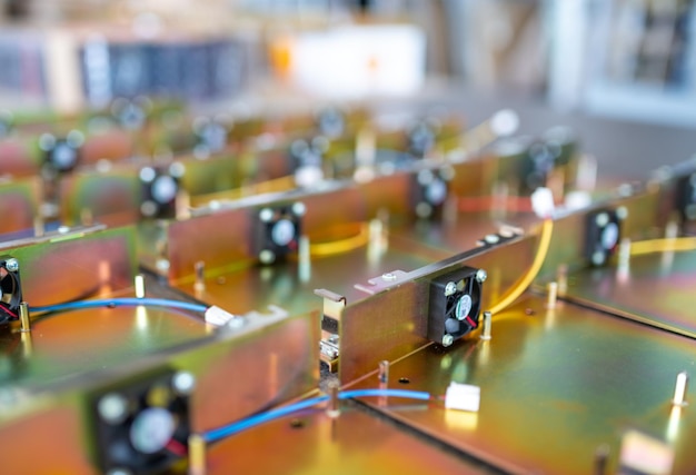 Regenbogenfarbene Metalldetails mit dünnen Kabeln für moderne TFT-Displays auf einem großen Tisch in der Montagewerkstatt der Werksmakroansicht