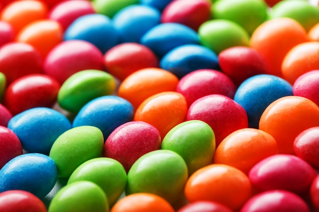 Regenbogenfarbene Süßigkeiten auf weißem Hintergrund