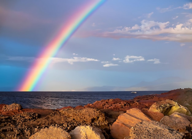 Regenbogenhimmel, rotes Meer aus Stein