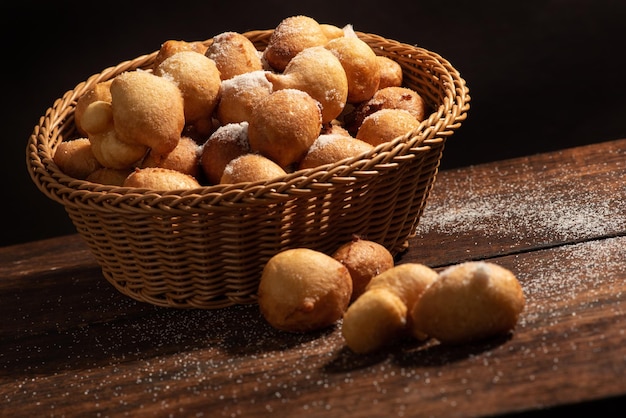 Regenkuchenkorb mit Regenkuchen auf rustikalem Holz mit selektivem Fokus des schwarzen Hintergrundes