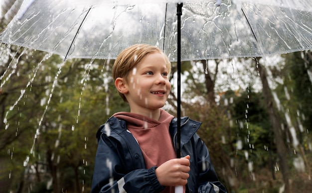 Regenporträt eines jungen und gutaussehenden Jungen