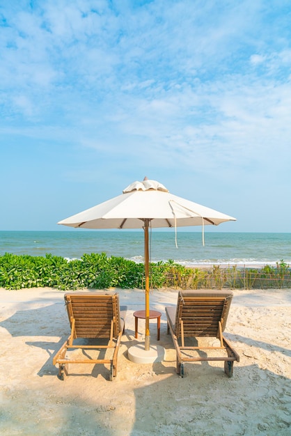 Regenschirm mit Strandkorb und Ozean-Meer-Hintergrund - Urlaubs- und Urlaubskonzept