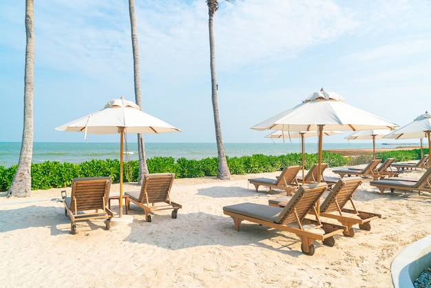 Regenschirm mit Strandkorb und Ozean-Meer-Hintergrund - Urlaubs- und Urlaubskonzept