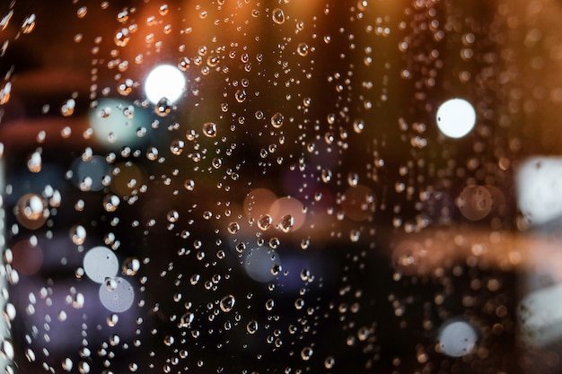 Regentropfen am Fenster in der Nacht.