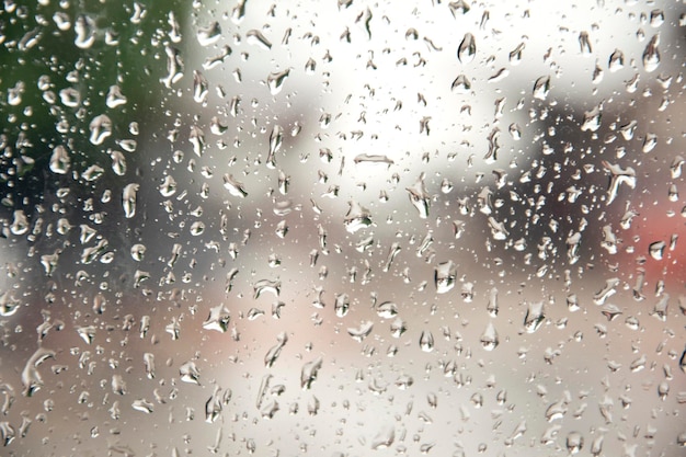 Regentropfen auf dem Autoglas Blick auf die Straße durch das Autofenster mit Regentropfen Fahren im Regen