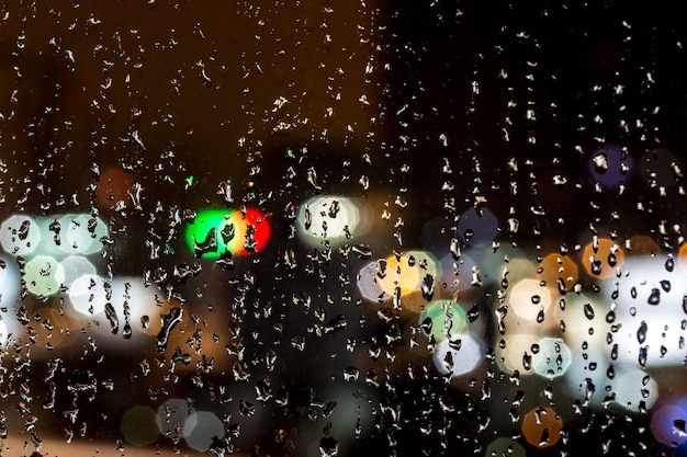 Regentropfen auf Fenster, Nacht, Nahaufnahmehintergrund