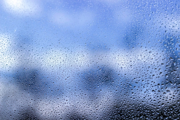 Foto regentropfen auf fensterglas auf blauer farbe xdxa