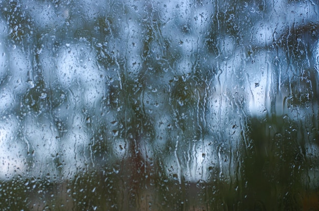 Regentropfen auf Fensterglasoberfläche mit Bokeh-Hintergrund