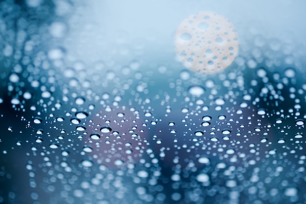 Regentropfen auf Glas mit Bokeh Licht im Hintergrund