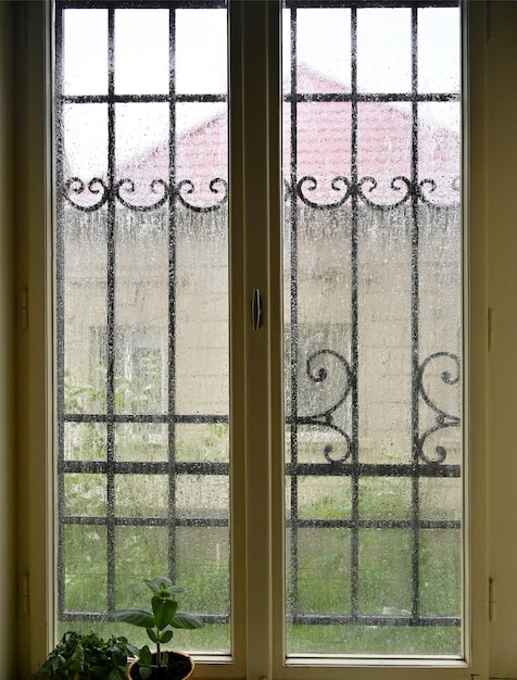 Regentropfen fließen durch die Fenster der Wohnung