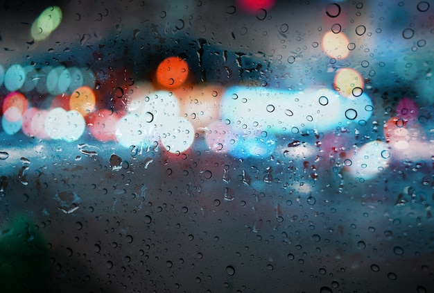 Regentropfen mit hellem bokeh auf dem Straßenregen-Saisonhintergrund