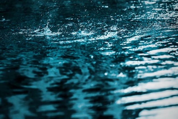 Regentropfen spritzen im Swimmingpool