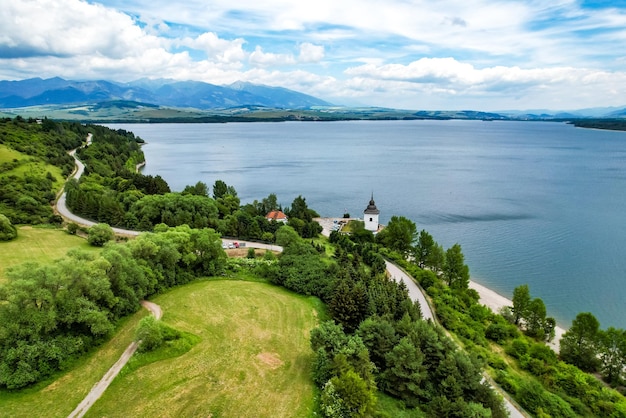 Región de Liptov en la procedencia con el lago Liptovska mara y las montañas Tatras alrededor de Liptovsky mikulas landspace Eslovaquia Torre de la Iglesia de la Virgen María