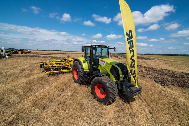 REGION TERNOPIL, UKRAINE - 10. August 2021: Traktor CLAAS mit gezogenen Eggen Bednar bei der Vorführung von Landmaschinen, Ausstellung der Firma Lan