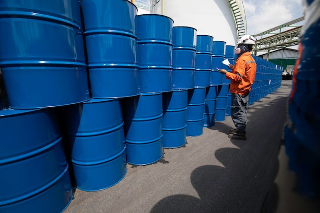 Registro de inspección de trabajadores masculinos barriles de existencias de aceite de tambor azul horizontal o químico puesto en una media máscara facial