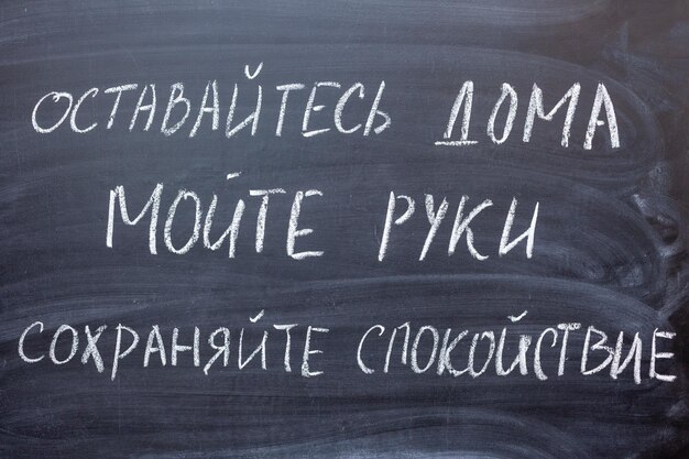 Reglas de comportamiento pandémico de coronavirus o consejos de salud. Escribe en ruso en una pizarra 1) quédate en casa 2) lávate las manos 3) mantén la calma.