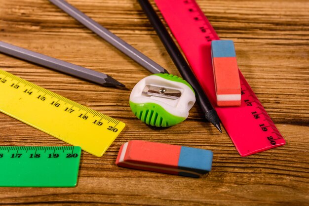 Reglas, lápices y borradores en una mesa de madera