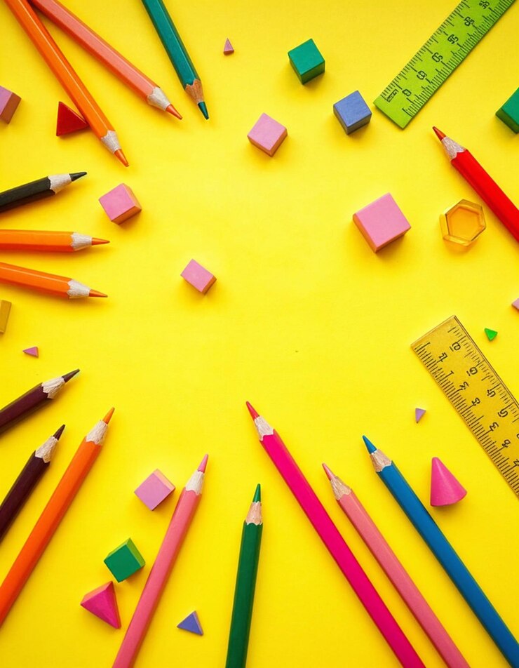 Reglas y lápices de colores sobre un fondo amarillo
