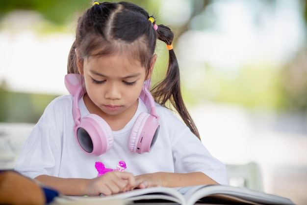 Regreso a la escuela Chica asiática leyendo un libro Estudiantes de escuela primaria después de clases aprendiendo la tarea