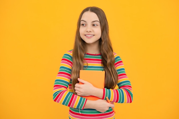 Regreso a la escuela Colegiala adolescente con libro listo para aprender Niñas de la escuela sobre fondo de estudio amarillo aislado