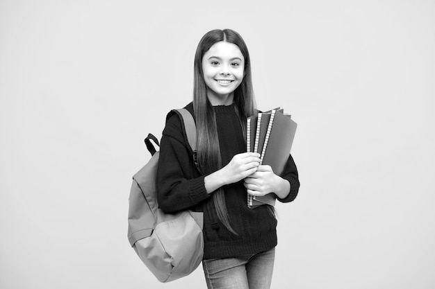 Regreso a la escuela Colegiala adolescente mantenga el libro y el cuaderno listo para aprender Niños de la escuela sobre fondo de estudio amarillo aislado