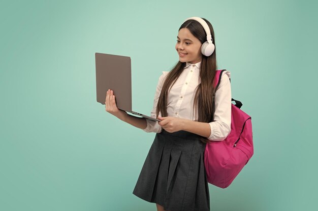 Regreso a la escuela Colegiala adolescente en uniforme escolar con auriculares de mochila y computadora portátil